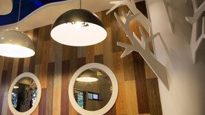 A modern interior with wooden panel walls, three pendant lights, and a large mirror. - Star of Bethlehem BnB (Wujie)
