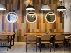 A modern dining area with a wooden wall, round mirrors, and pendant lighting. - Star of Bethlehem BnB (Wujie)
