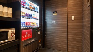 A vending machine with a variety of drinks and a red sign with Japanese text. - APA Hotel Iidabashi Ekimae (Tokyo)