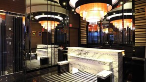 A modern hotel lobby with a marble reception desk, glass doors, and chandeliers. - APA Hotel Iidabashi Ekimae (Tokyo)