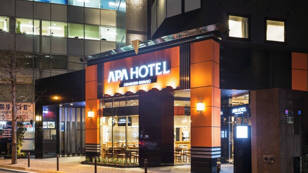The exterior of APA Hotel with a modern design, featuring a prominent entrance and visible seating area outside. - APA Hotel Iidabashi Ekimae (Tokyo)