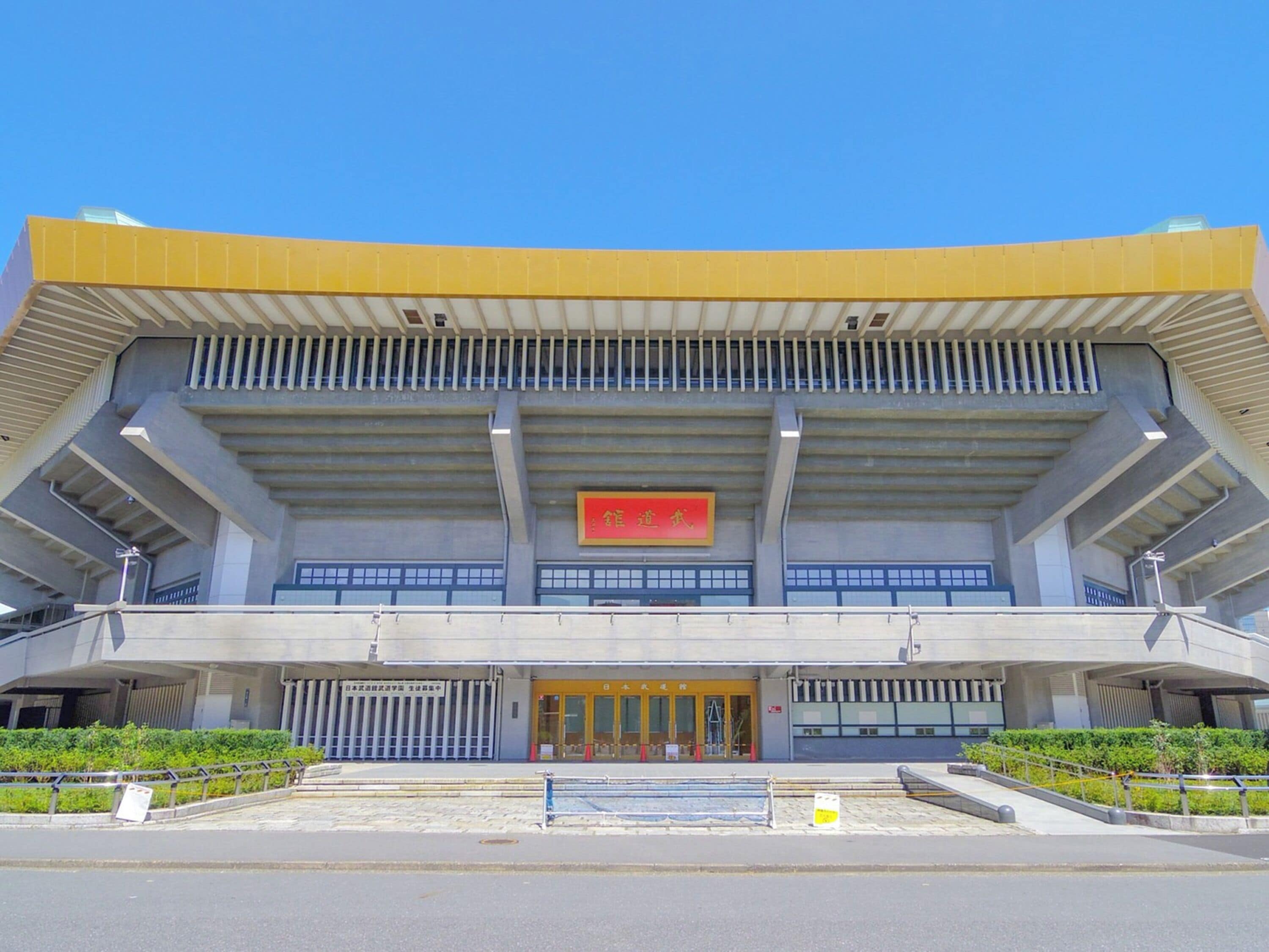 A large, modern building with a prominent yellow roof and a red sign above the entrance.