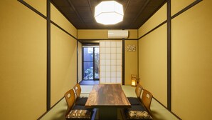 Une pièce de style japonais traditionnel, avec un sol recouvert de tatamis, une table en bois et des paravents en papier.