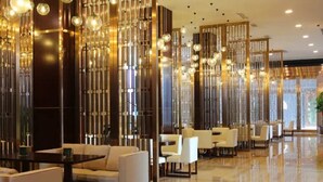 A modern hotel lobby with a polished floor, seating areas, and decorative light fixtures. - Country Garden Golden Beach Spring Hotel (Lingao)
