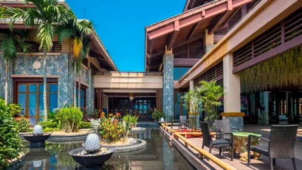 A hotel courtyard with a central water feature, outdoor seating, and tropical plants. - Country Garden Golden Beach Spring Hotel (Lingao)