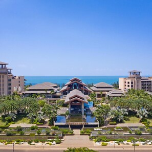 A resort with multiple buildings, a central pool area, and a view of the ocean. - Country Garden Golden Beach Spring Hotel (Lingao)