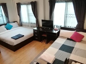 A hotel room with two beds, a desk, and a TV. - The Cube Sathorn Boutique (Bangkok)