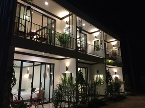 A modern two-story building with balconies, large windows, and potted plants. - Sofinny Motel (Sihanoukville)