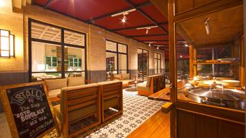 A restaurant interior with wooden furniture, a chalkboard sign, and a tiled floor.