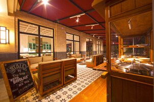 A restaurant interior with wooden furniture, a chalkboard sign, and a tiled floor.