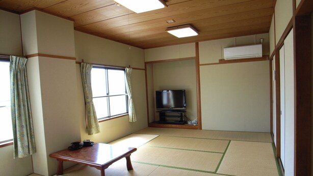 A traditional Japanese room with tatami flooring, a low table, a television, and sliding doors. - Tabist Hirofune Koyo IC (Nagoya)