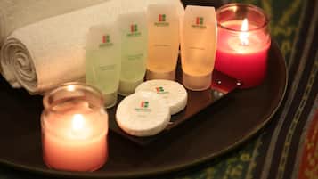 Un plateau contenant des produits de bain, une bougie et une serviette enroulée.