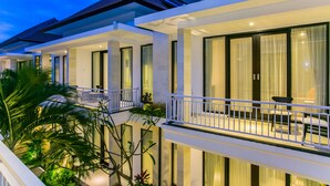 Un hôtel moderne doté de nombreux balcons, de grandes fenêtres et d’une végétation luxuriante.
