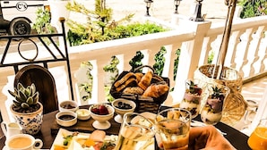 A dining table set with various dishes, drinks, and a view of a vehicle in the background. - Conny's Boutique Hotel - Adults Only (Manavgat)