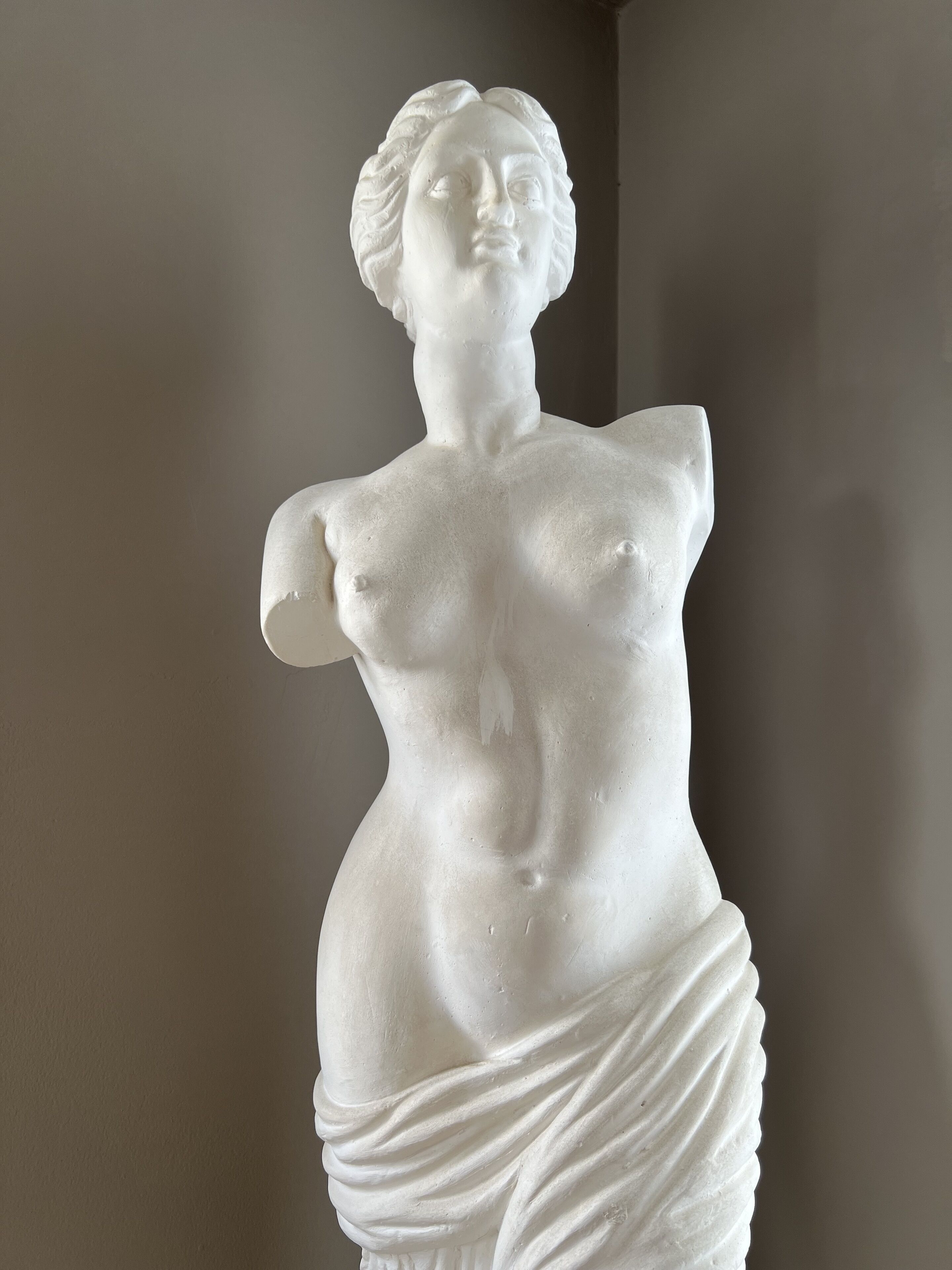 A white marble statue of a draped female figure.