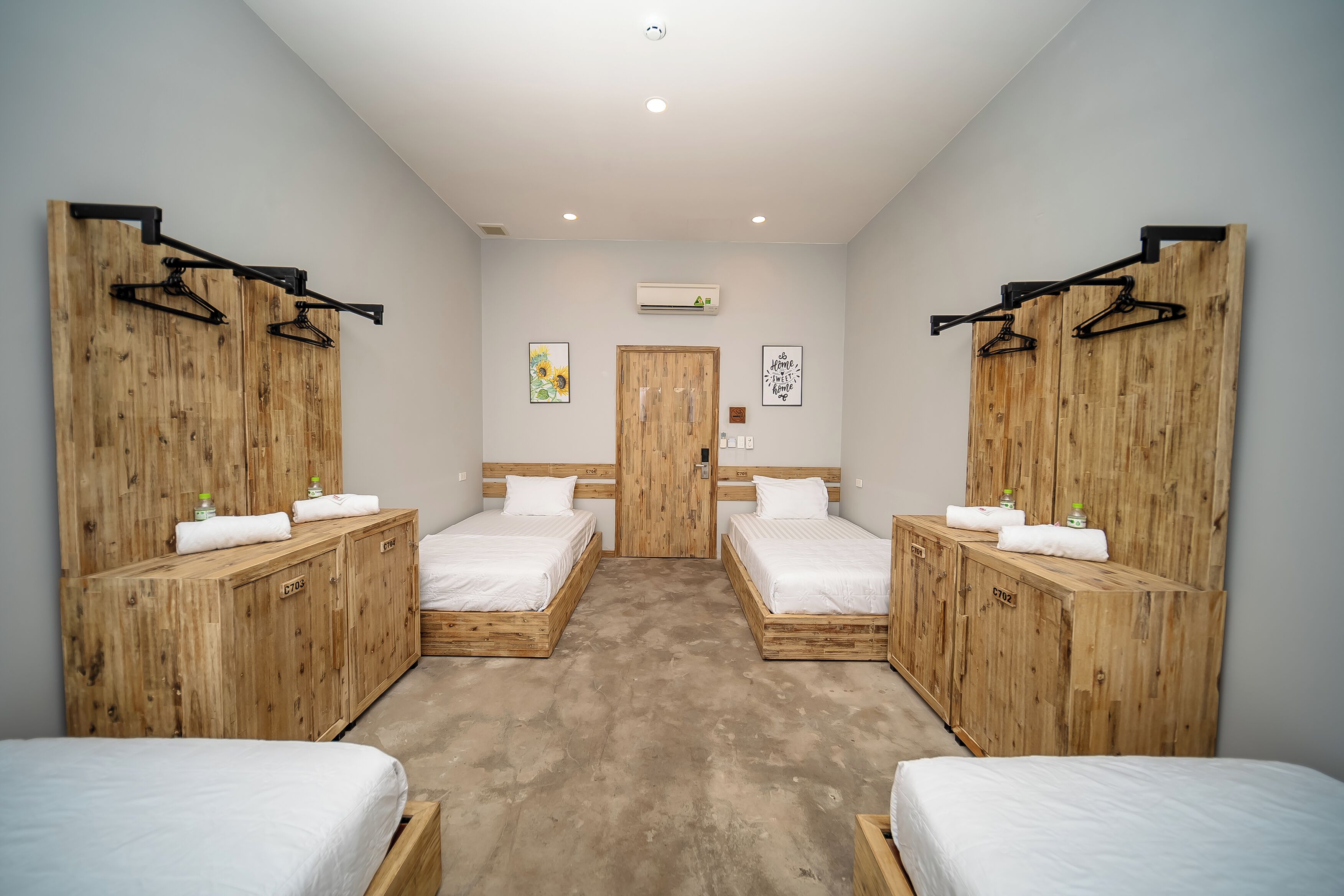 Una habitación con dos camas, armarios de madera y una puerta.