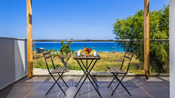 A wooden pergola with a table and chairs overlooking a beach. - Rhodes Sea Villas (Rhodes)