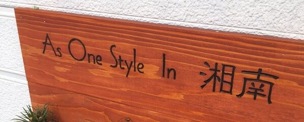 A wooden sign with the text "As One Style In - 湘南".