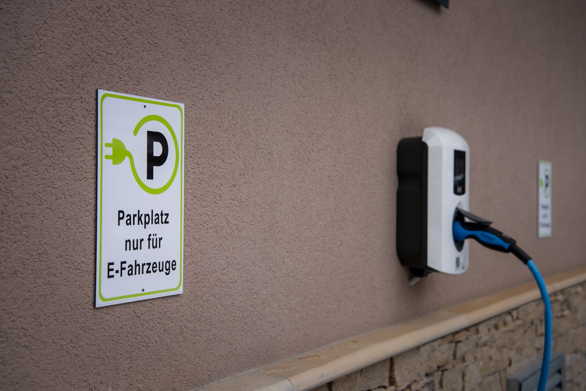 Señal de estacionamiento para vehículos eléctricos y estación de carga para vehículos eléctricos.