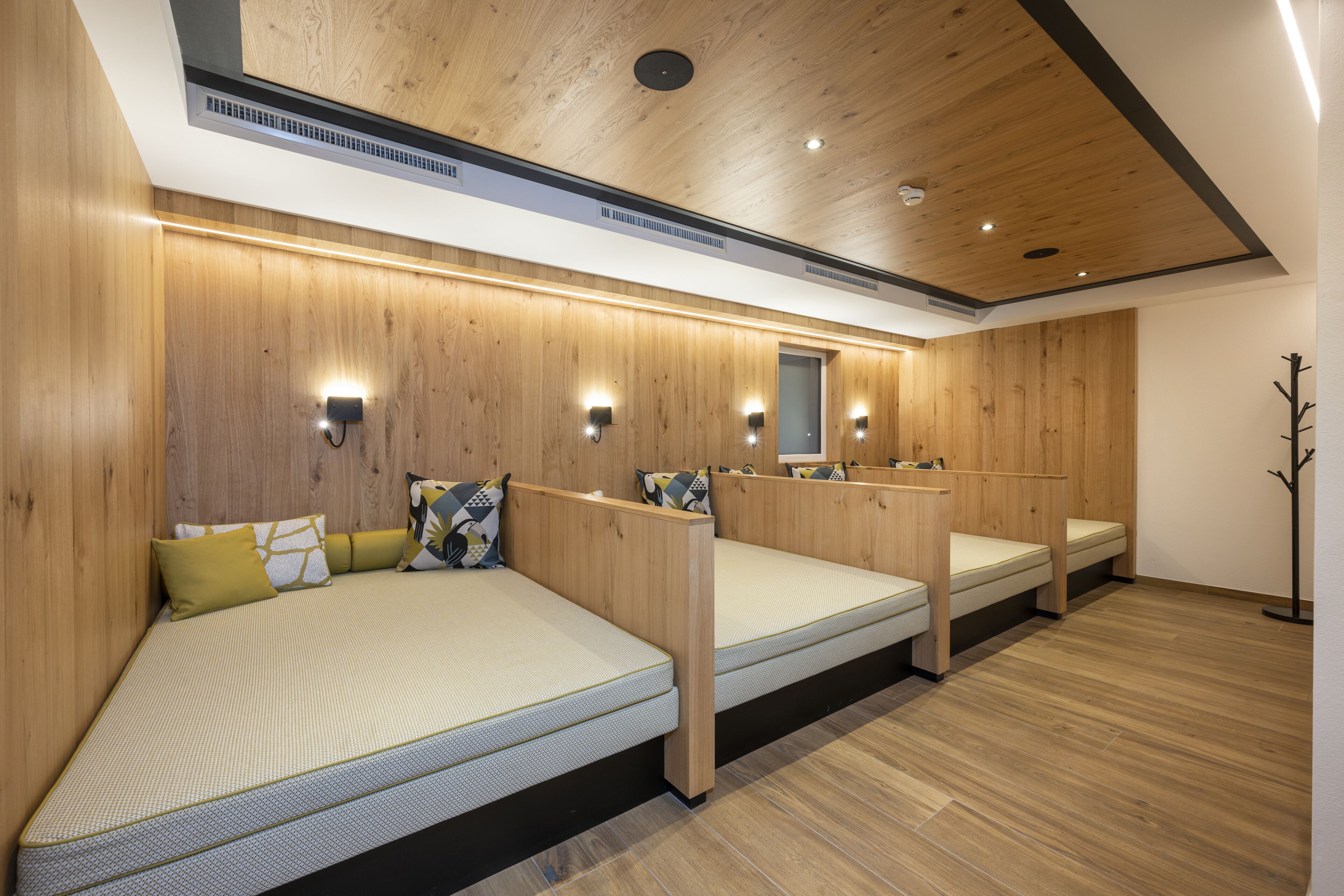Ein Zimmer mit drei Holzbetten, jeweils mit Matratze und Kissen, sowie einem Holzboden.