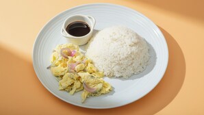 A plate with white rice, scrambled eggs with onions, and a small bowl of sauce. - Hotel Juliano (Manila)