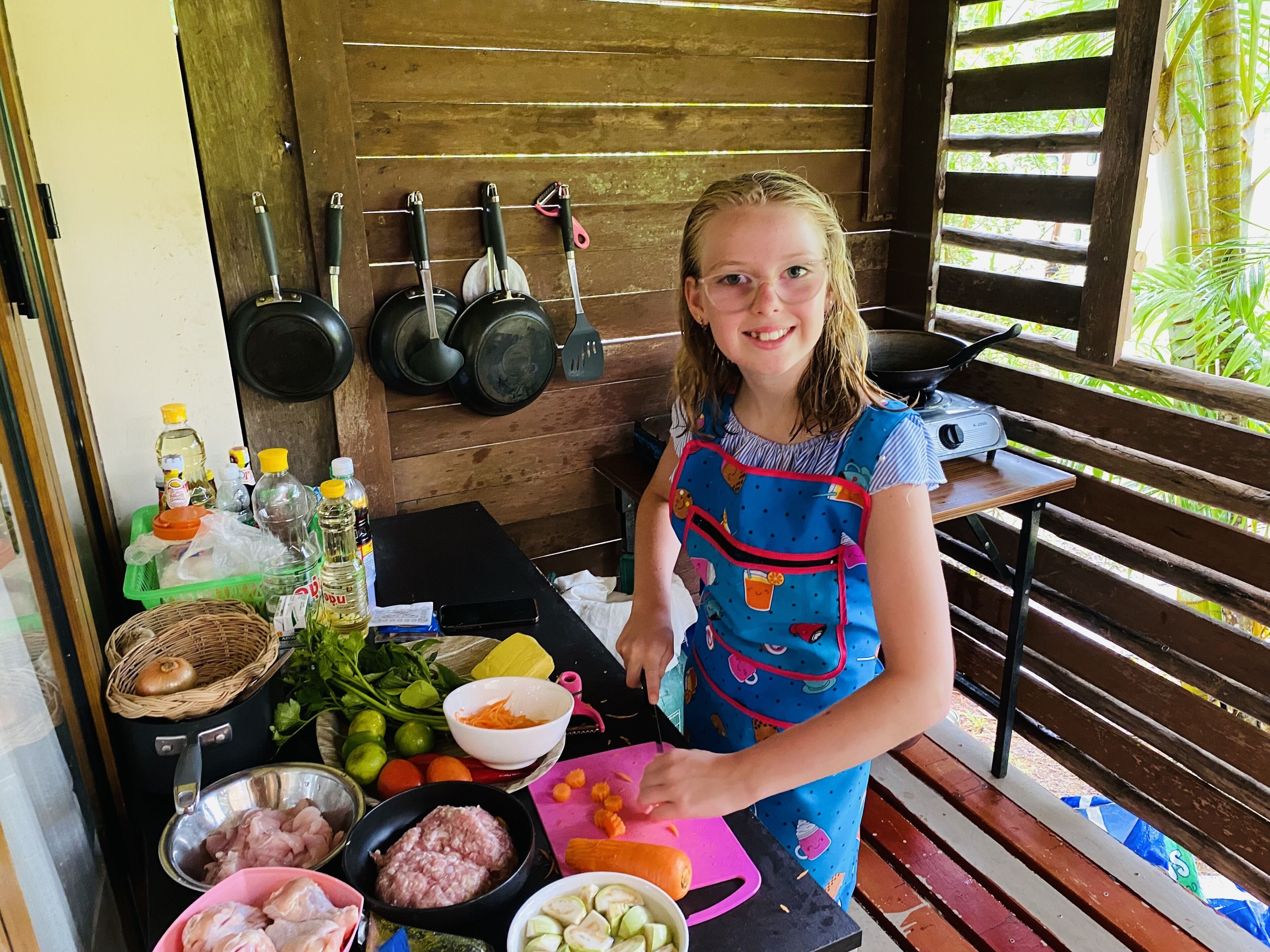 Una persona preparant menjar amb diversos ingredients i utensilis damunt d'una taula.
