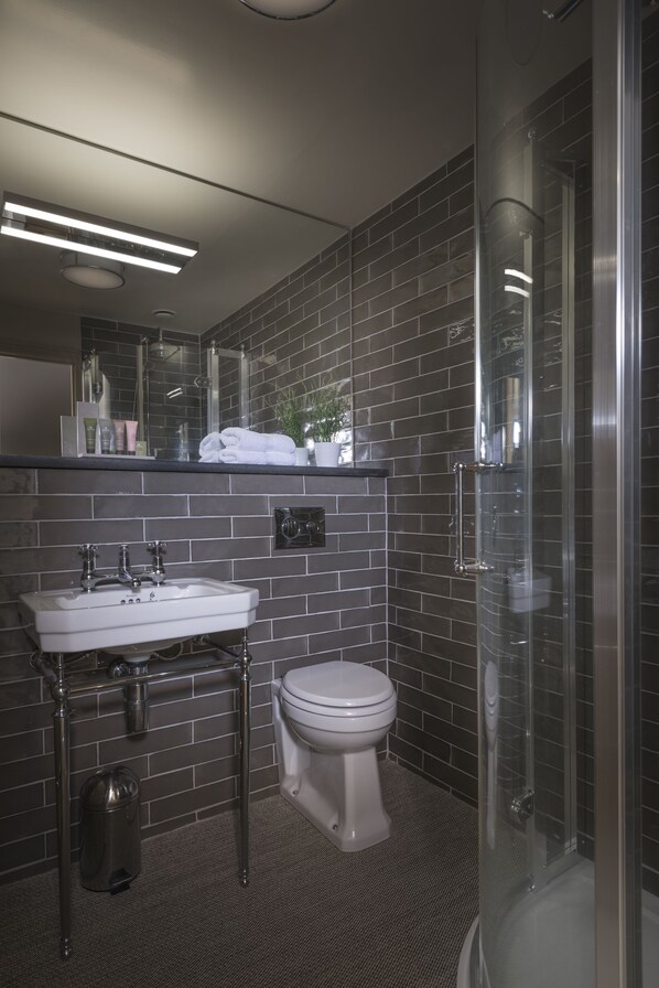 A modern bathroom with a white sink, a toilet, and a glass-enclosed shower area. - Harper's Steakhouse with Rooms, Haslemere (Haslemere)