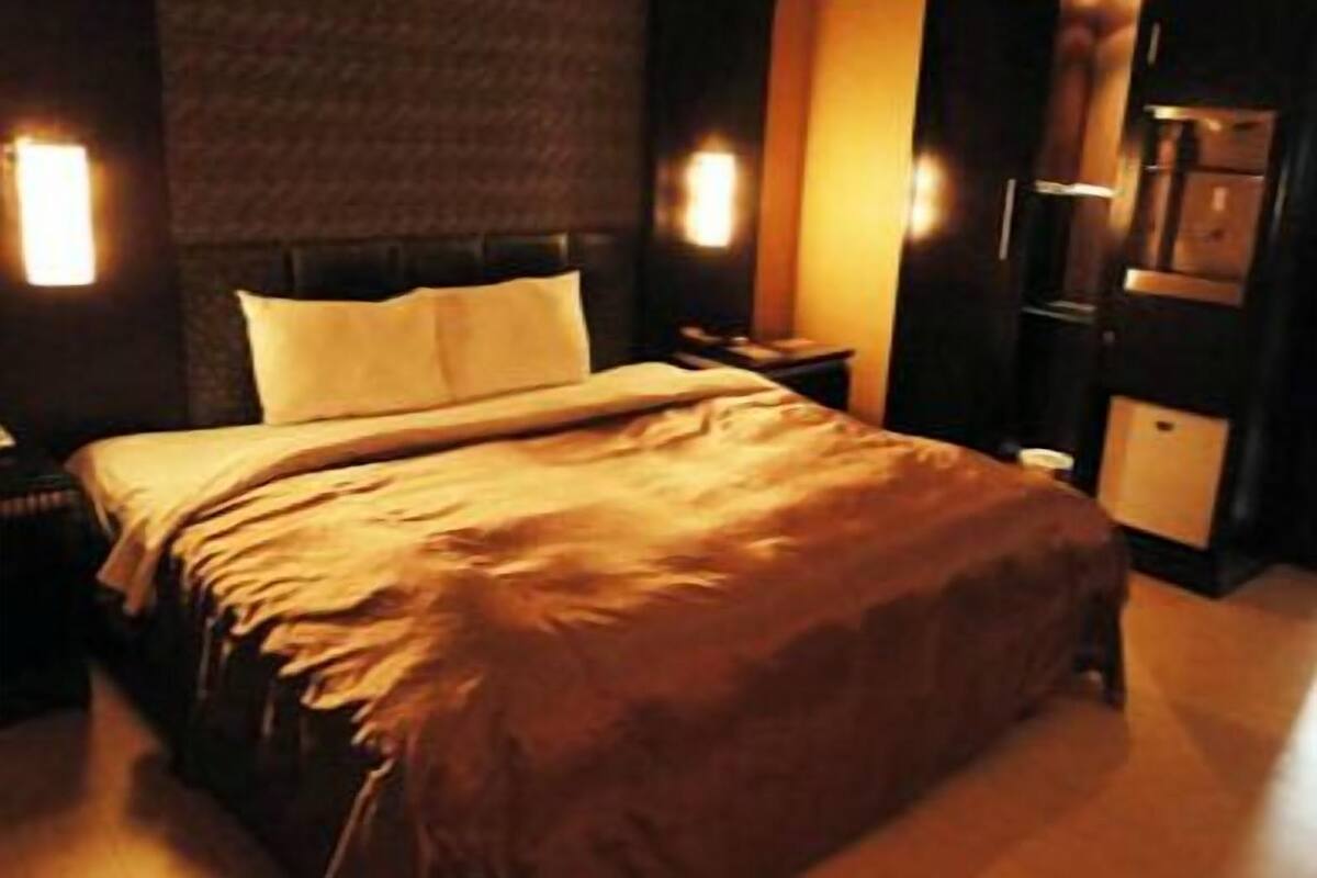 A neatly made bed with a headboard, a bedside table, and a nightstand.