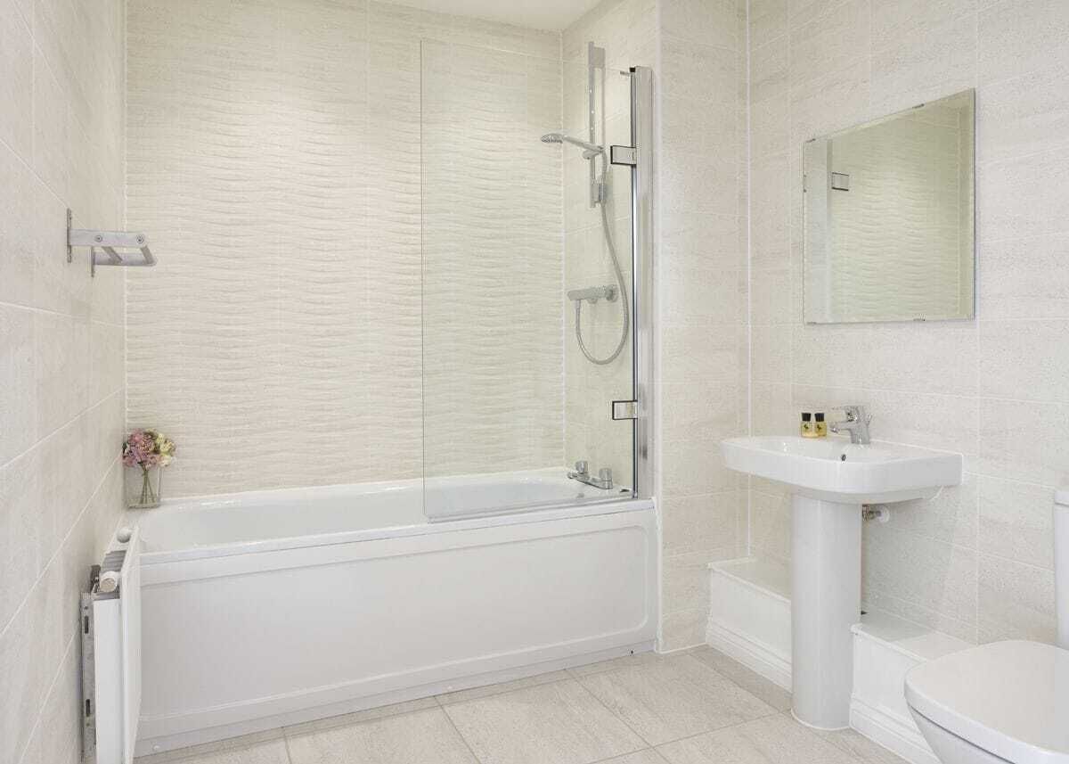 Un baño con bañera, ducha, lavamanos e inodoro.