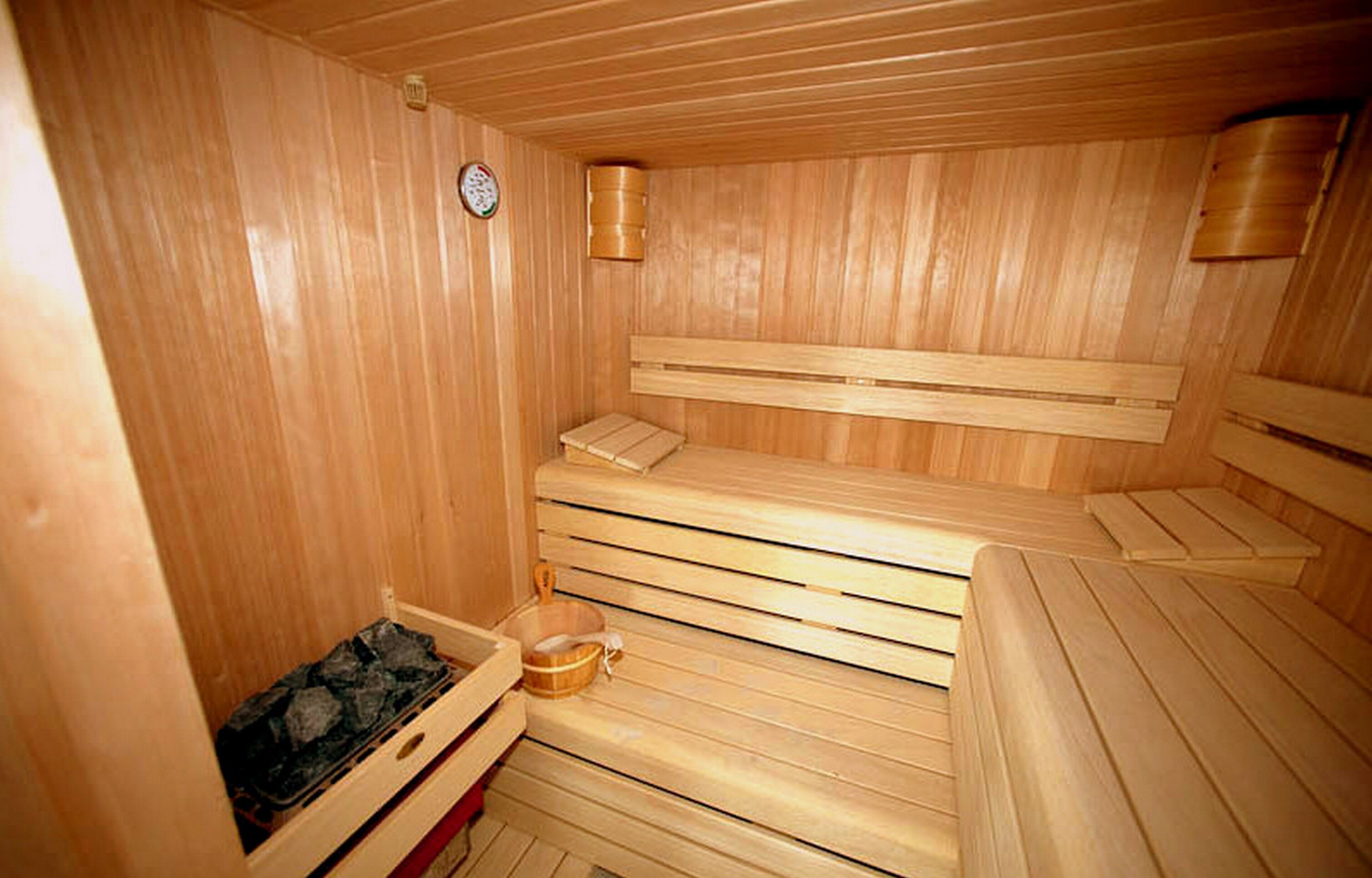 A sauna with wooden benches and a small wooden bench.