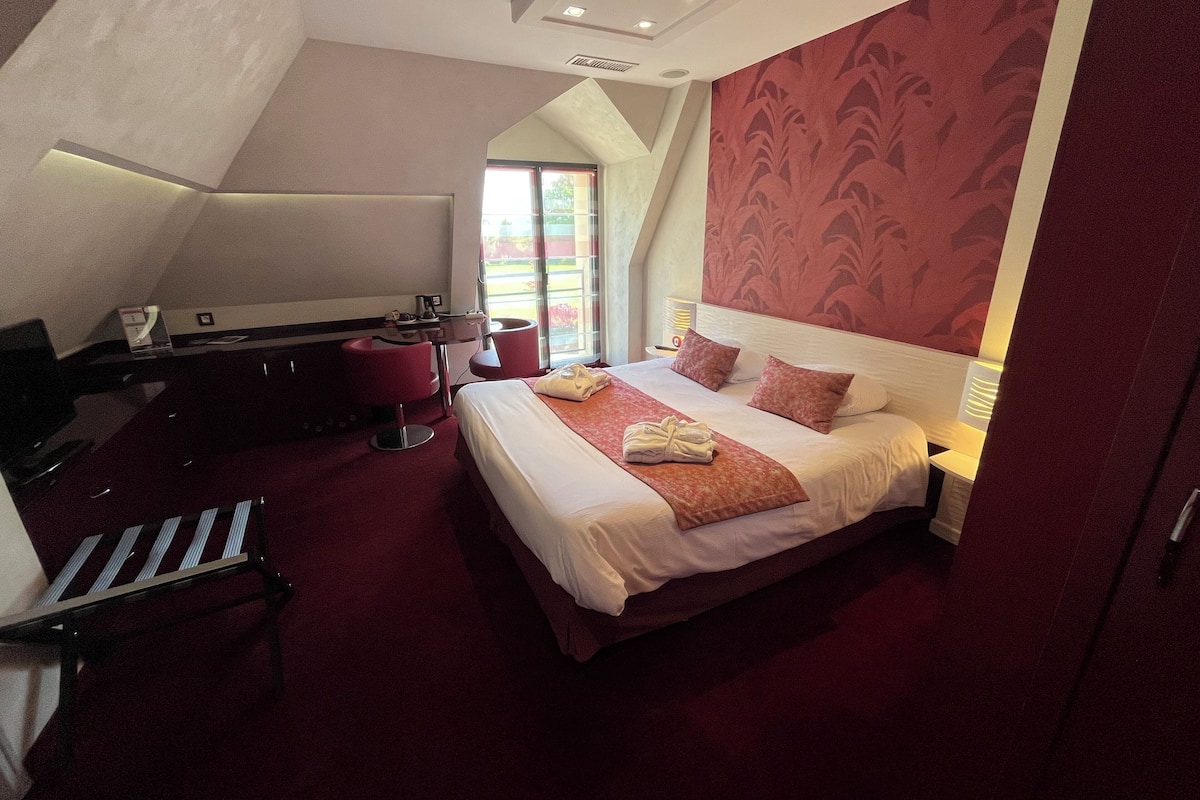 Een hotelkamer met een bed, een bureau en een stoel.