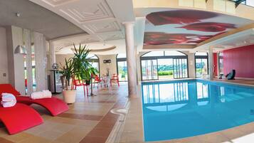 Una piscina techada, sillones reclinables de piscina