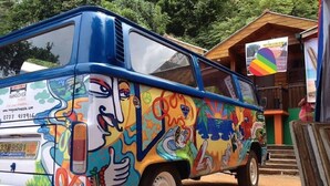 A colorful van with a hand-painted design, parked in front of a building with a rainbow flag. - Hangover Hostels at Mirissa (Mirissa)