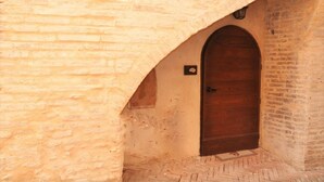 A stone building with a wooden door and a small sign above it.