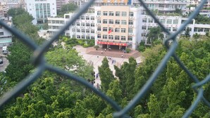 A multi-story building with a central courtyard, surrounded by trees.