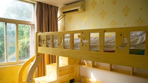 A bunk bed room with a window, curtains, and a wall-mounted air conditioner.