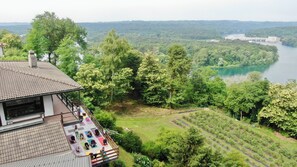 A house with a balcony overlooking a river and forest.