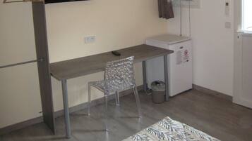 A small, modern room with a desk, chair, and a radiator.