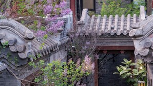 A traditional courtyard with stone architecture, lanterns, and flowering plants. - Beijing Le Zai Nan Luo Gu Xiang Wang Fu Jing Forbidden City Courtyard Hotel (Beijing)