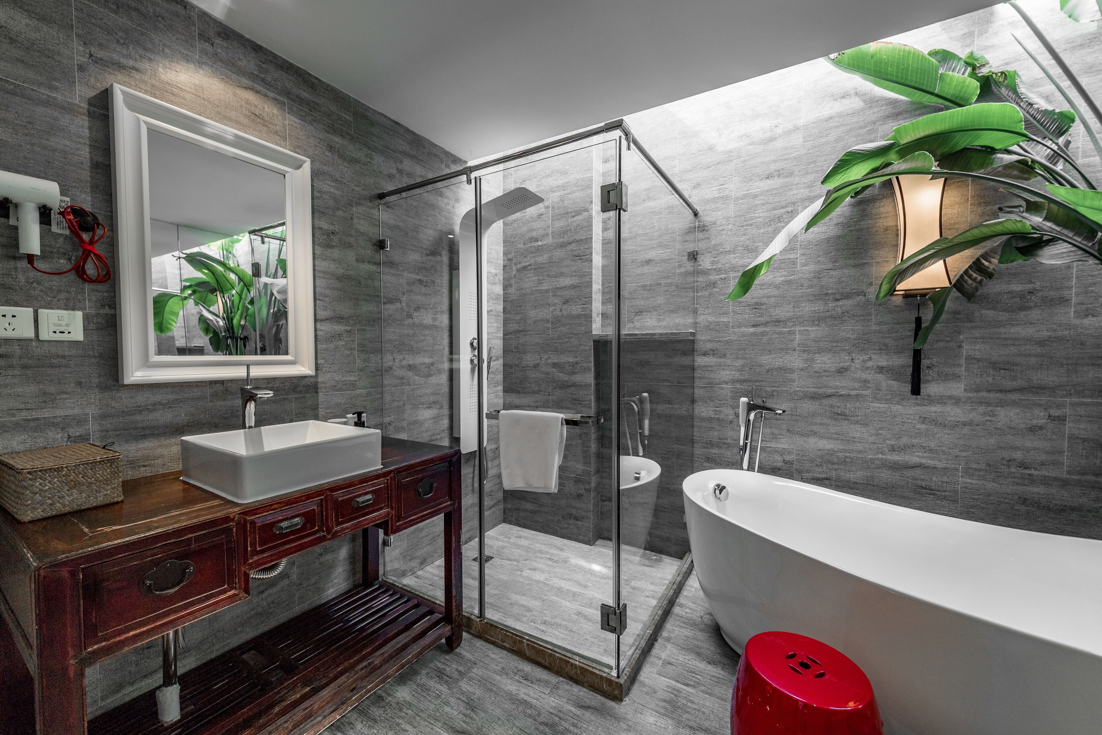 Une salle de bain moderne dotée d’une douche à parois de verre, d’une baignoire sur pieds et d’un meuble-lavabo avec un miroir.