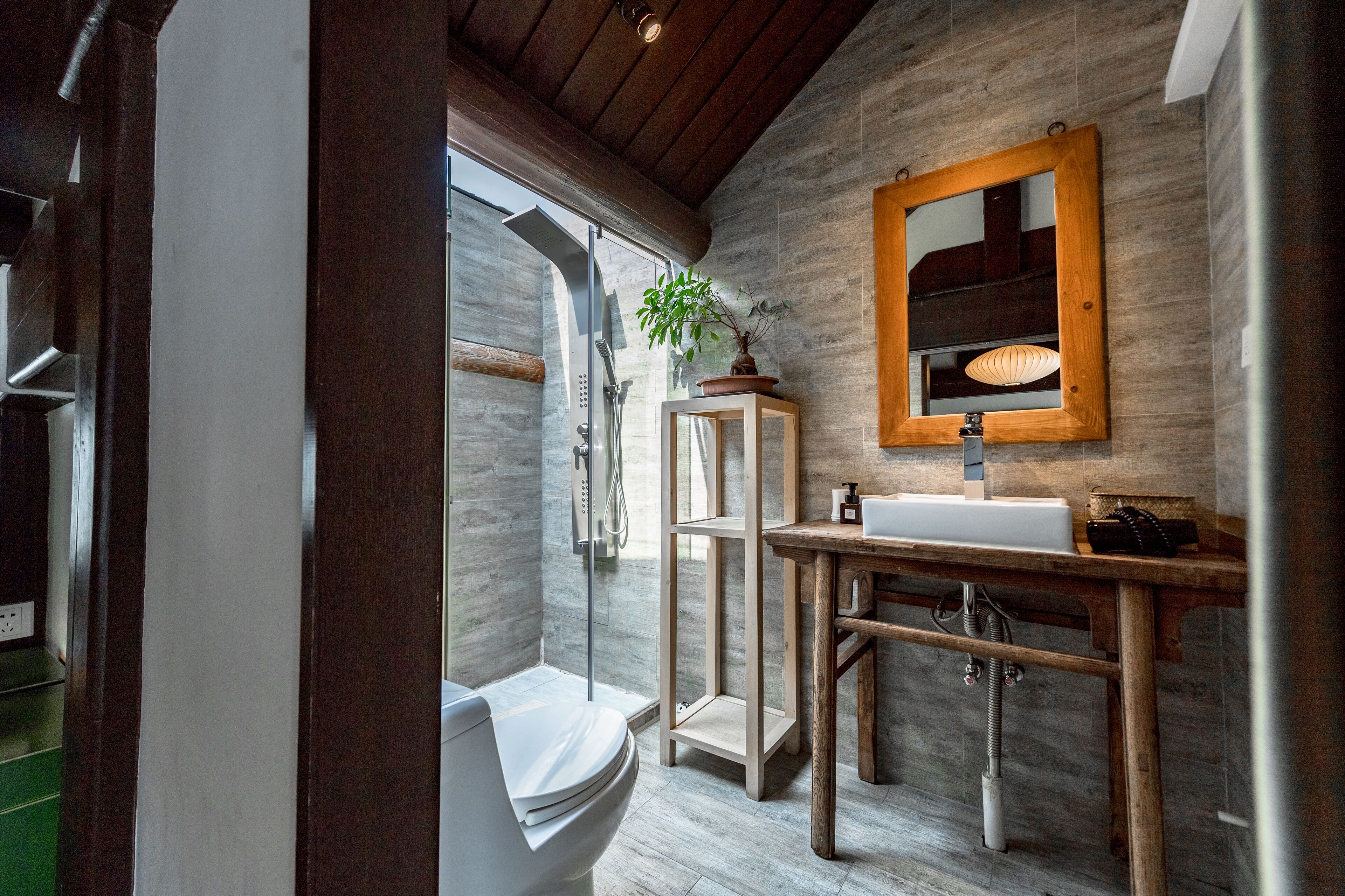 A modern bathroom with a shower, toilet, and sink.