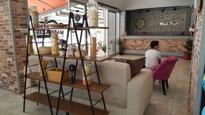 A modern interior with a brick wall, a reception desk, and a seating area with a sofa and a pink chair. - The Marmaris Boutique Hotel (Marmaris)