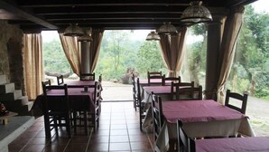 A restaurant with tables and chairs, a tiled floor, and curtains. - Casería La Infiesta (Caso)
