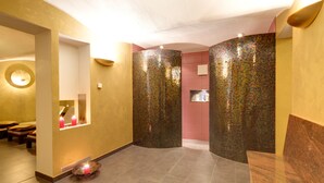 A spa area with a seating area, a mirror, and a decorative wall with mosaic tiles. - Parkhotel del Mar (Sassnitz)