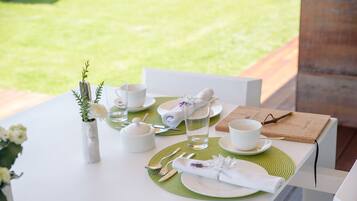 Een gedekte tafel met witte borden, bestek en een groene placemat.