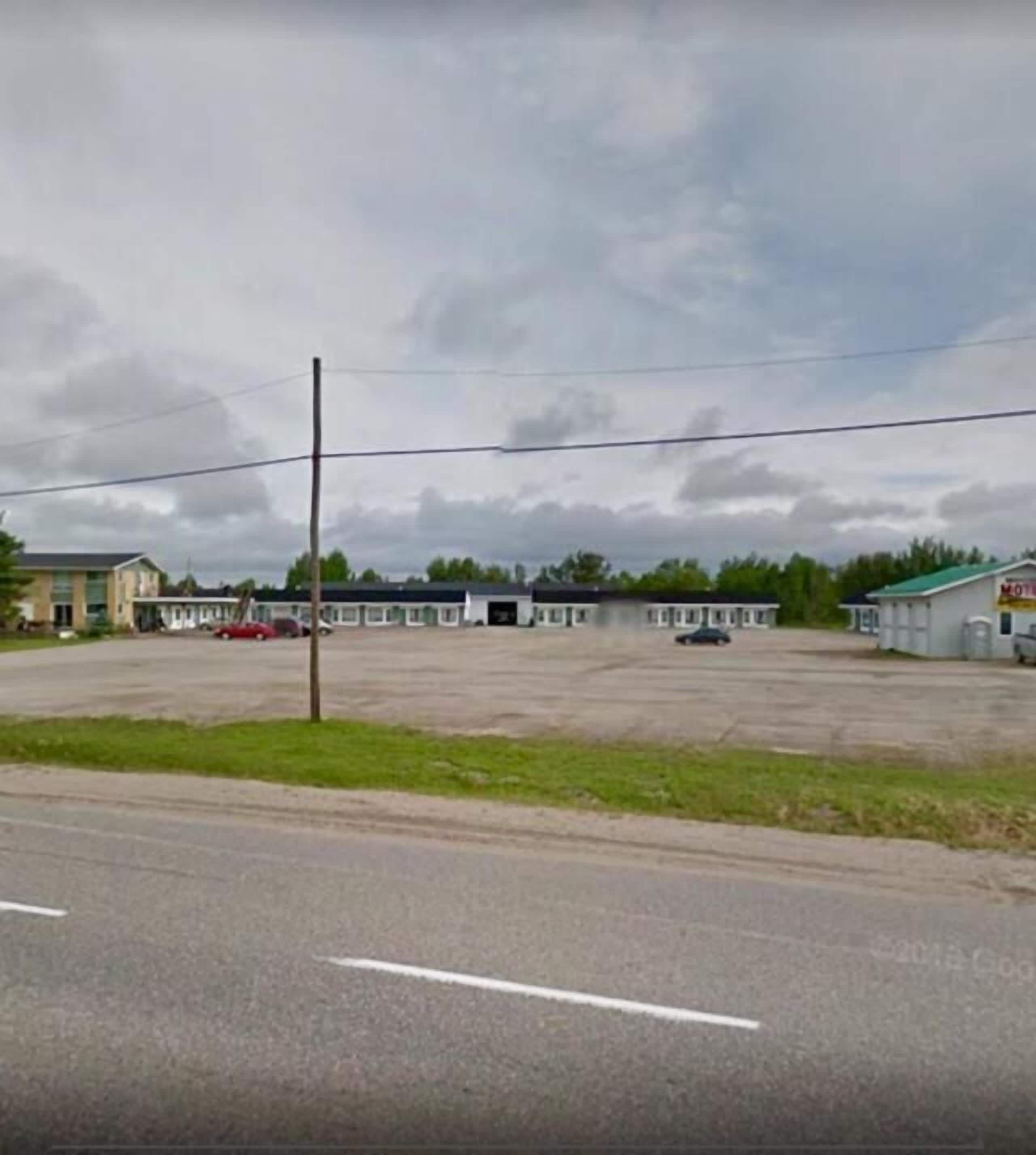 A large, empty parking lot with several buildings in the background.