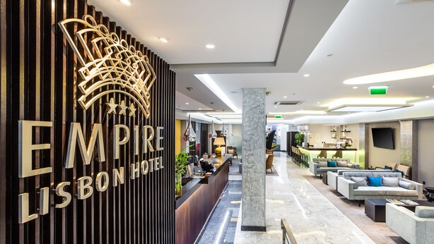 Un hall d’hôtel moderne comprenant un comptoir d’accueil, un espace salon et un grand panneau décoratif.