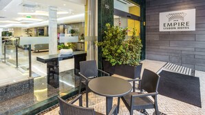 Un hall d’hôtel moderne avec un comptoir d’accueil, un espace salon et une plante en pot.