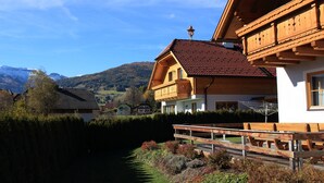 Un chalet traditionnel avec une façade en bois, un toit recouvert de tuiles rouges et un balcon.