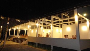 Un edificio moderno con un espacio exterior cubierto y varios arreglos de asientos.